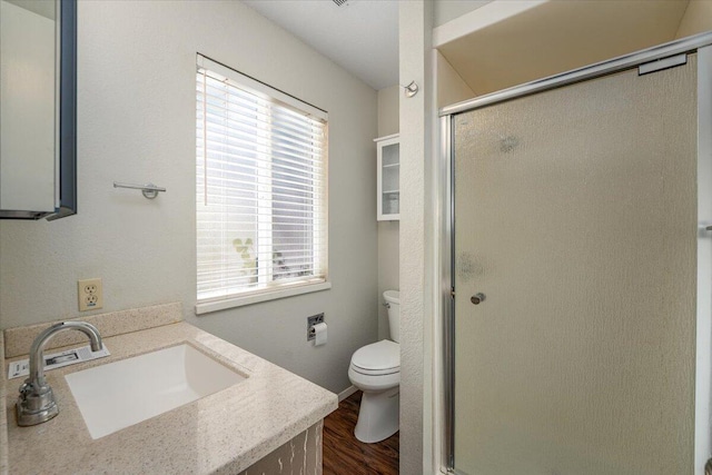 bathroom with plenty of natural light, toilet, wood-type flooring, and vanity