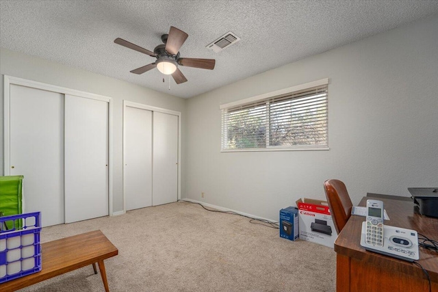 home office with carpet, a textured ceiling, and ceiling fan