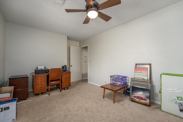 carpeted office featuring a textured ceiling and ceiling fan