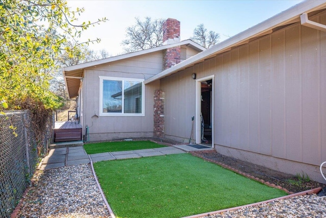 entrance to property with a lawn and a wooden deck