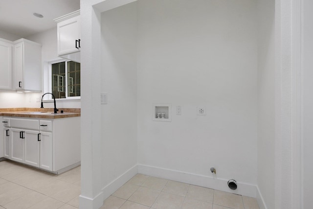 washroom featuring hookup for a washing machine, electric dryer hookup, sink, light tile patterned floors, and hookup for a gas dryer