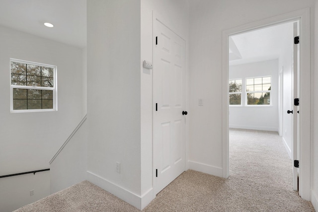 hallway featuring light colored carpet