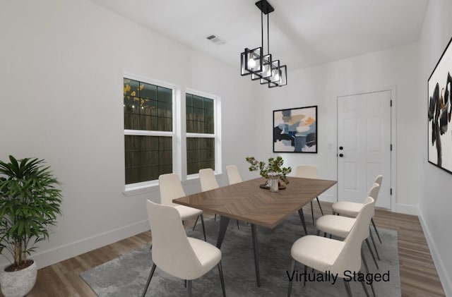 dining room featuring dark hardwood / wood-style floors and an inviting chandelier