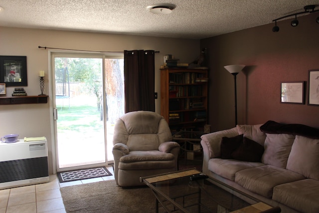 living room with light tile patterned floors, a textured ceiling, and heating unit