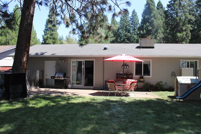 back of property with a lawn and a patio area