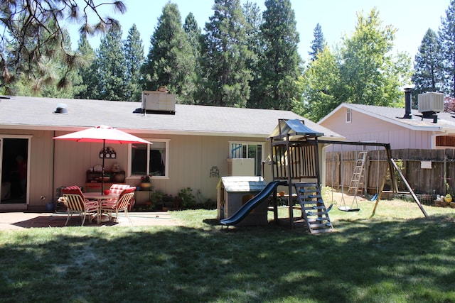 rear view of house with a playground, central AC, a lawn, and a patio