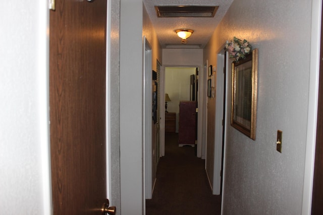 hall featuring a textured ceiling