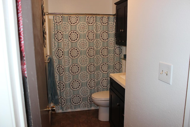 bathroom with toilet, vanity, and tile patterned floors