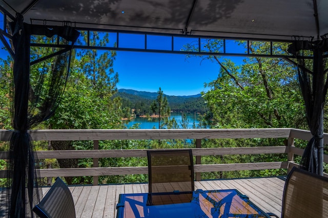 wooden deck featuring a water and mountain view