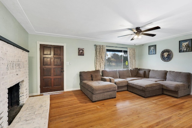 living room with ceiling fan, a fireplace, and wood-type flooring