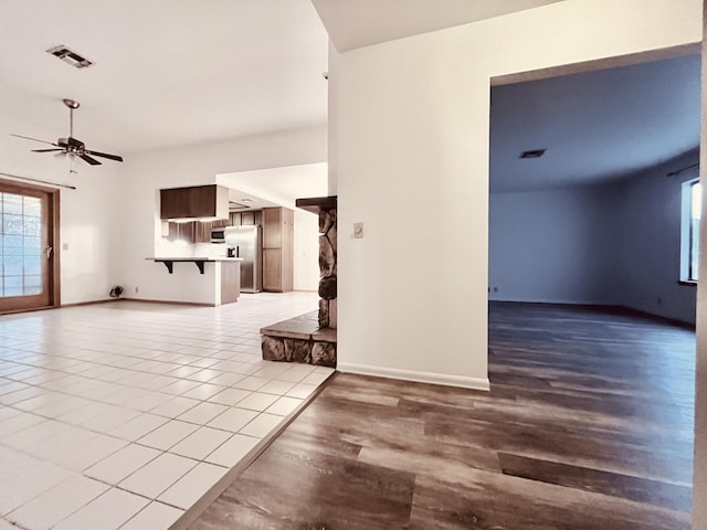 unfurnished living room featuring ceiling fan and light hardwood / wood-style flooring