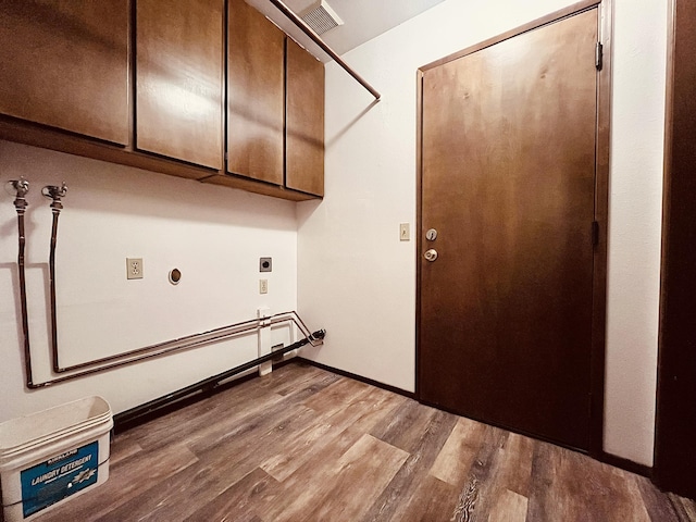 clothes washing area featuring cabinets, light hardwood / wood-style flooring, and electric dryer hookup