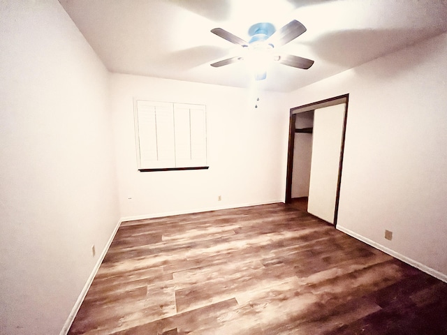 unfurnished bedroom featuring ceiling fan, wood-type flooring, and a closet