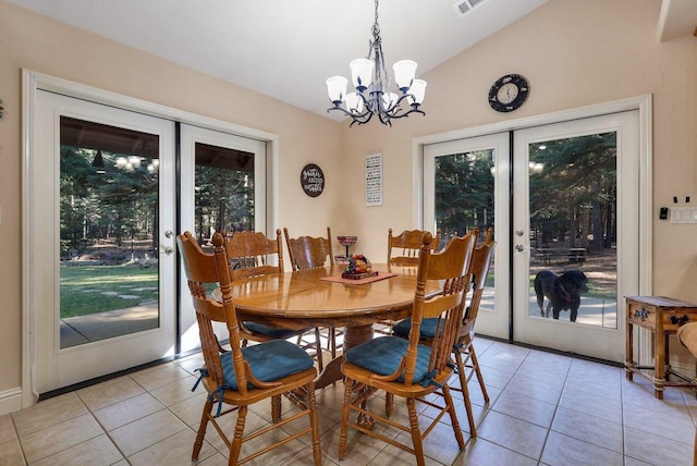 tiled dining room with a chandelier, french doors, and lofted ceiling