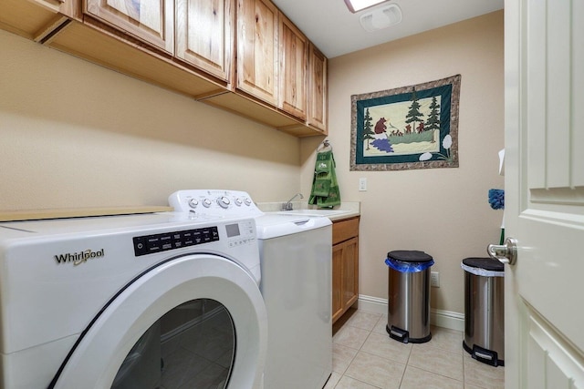 washroom with washer and dryer, light tile patterned flooring, and cabinets