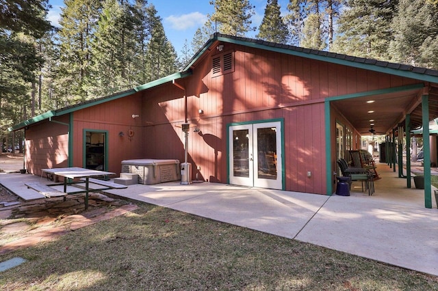 rear view of property with a hot tub, a patio, and french doors