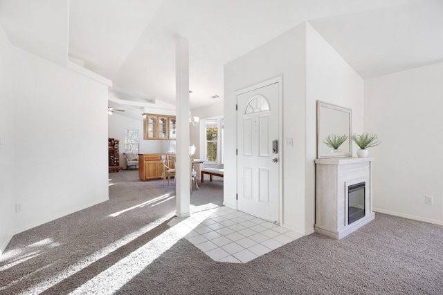 entryway featuring light carpet, ceiling fan with notable chandelier, and lofted ceiling