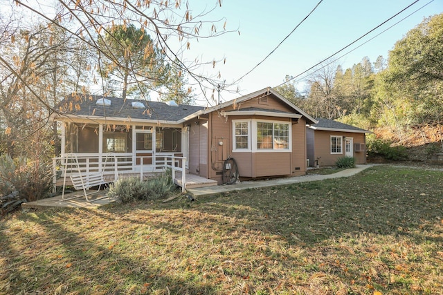 back of property featuring a lawn and a sunroom