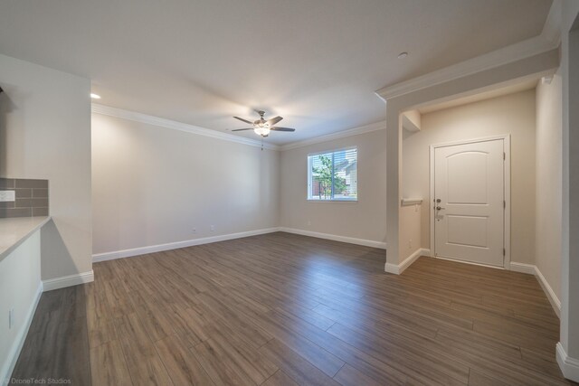 unfurnished living room with ceiling fan, crown molding, and dark hardwood / wood-style floors