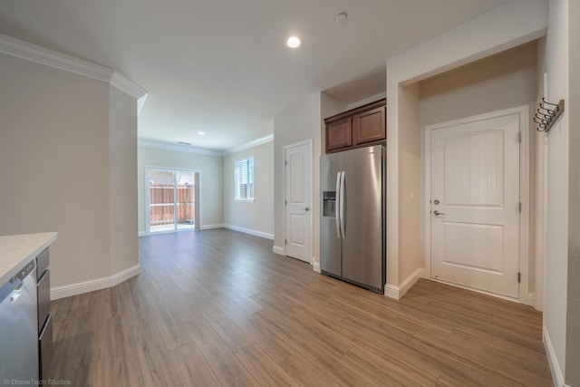 kitchen featuring light hardwood / wood-style flooring, stainless steel appliances, and ornamental molding