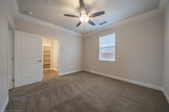 spare room with carpet flooring, crown molding, and ceiling fan