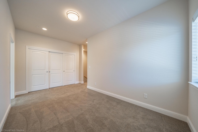 unfurnished bedroom with carpet flooring and a closet