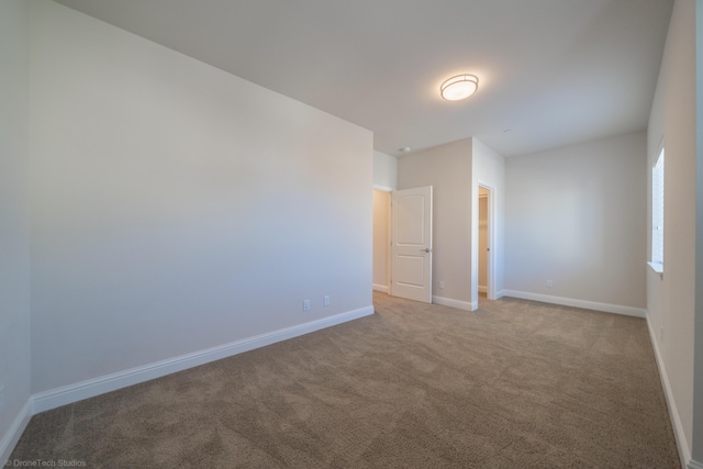 unfurnished room featuring light carpet