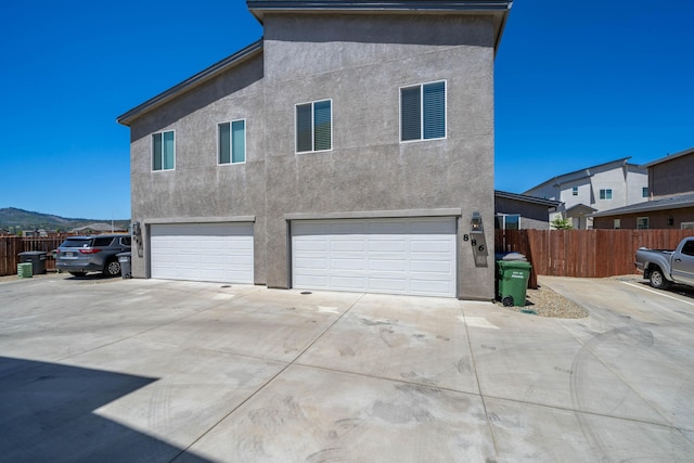 view of side of home with a mountain view and a garage