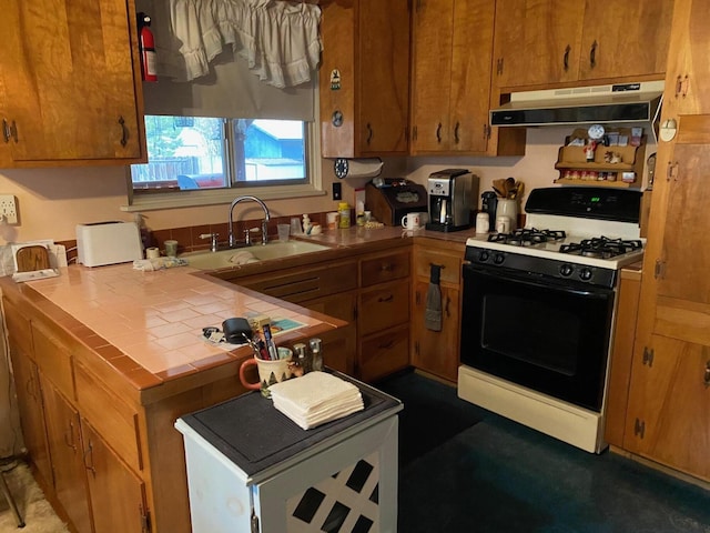 37412 Birch Ave, Burney, CA 96013 - kitchen with black gas range, under cabinet range hood, tile countertops, and brown cabinetry