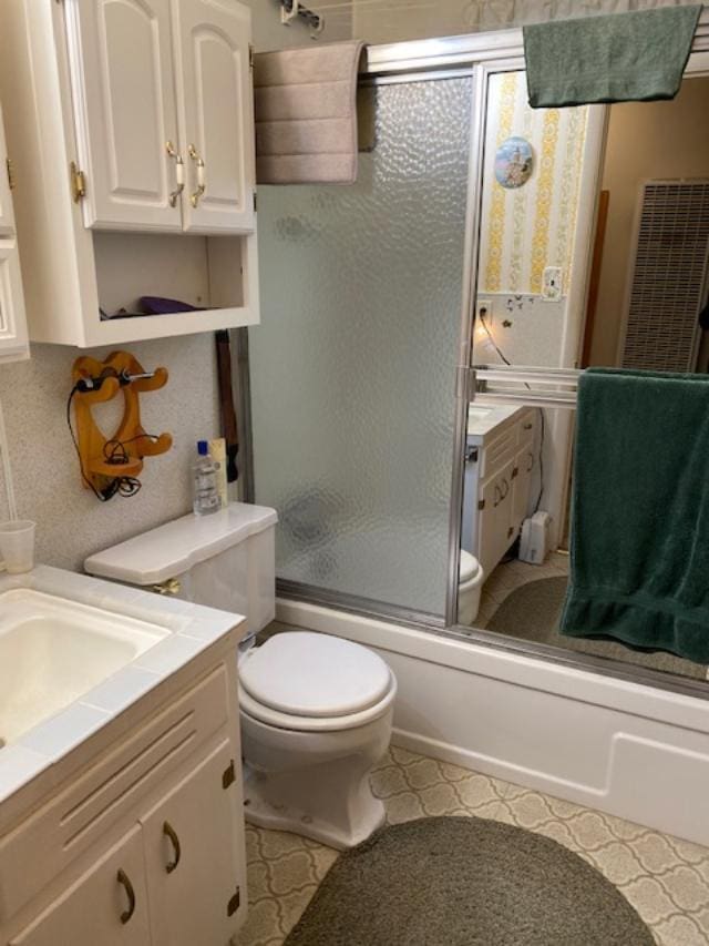 full bathroom featuring tile patterned floors, vanity, toilet, and shower / bath combination with glass door