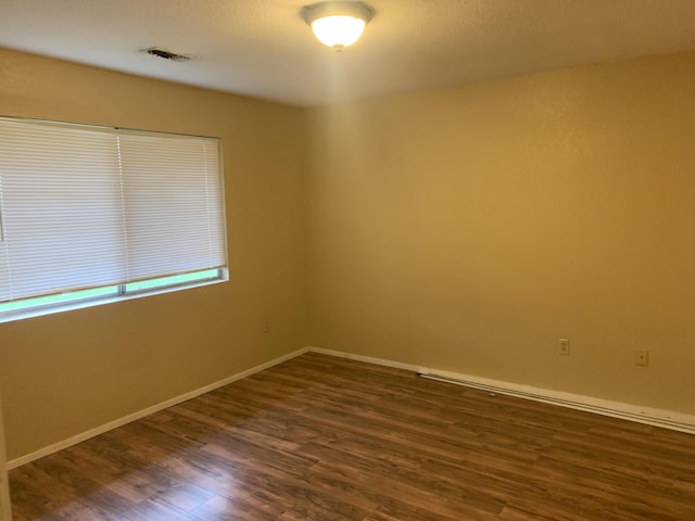 unfurnished room featuring dark wood-type flooring