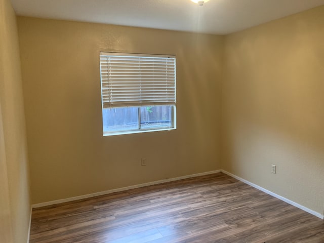 unfurnished room with hardwood / wood-style flooring