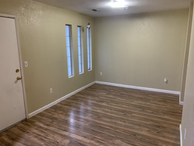 empty room with dark hardwood / wood-style flooring