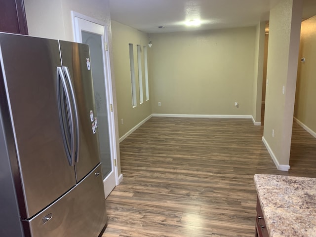 kitchen featuring stainless steel fridge and dark hardwood / wood-style flooring