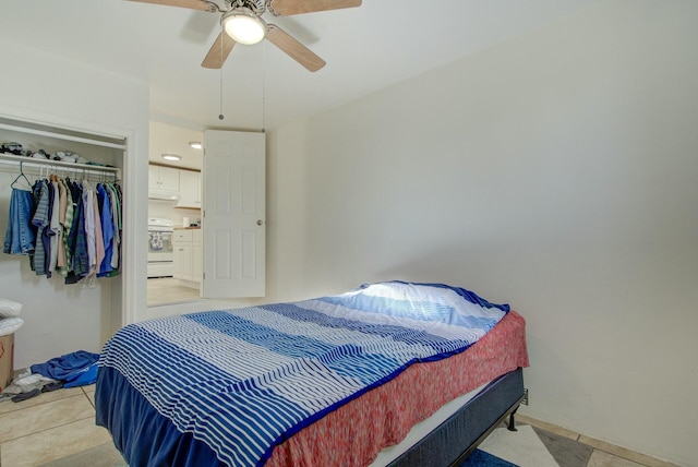 tiled bedroom featuring ceiling fan and a closet