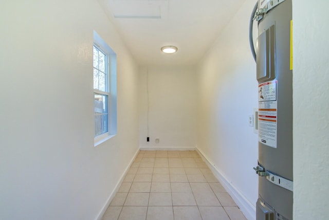 laundry room with water heater and light tile patterned flooring