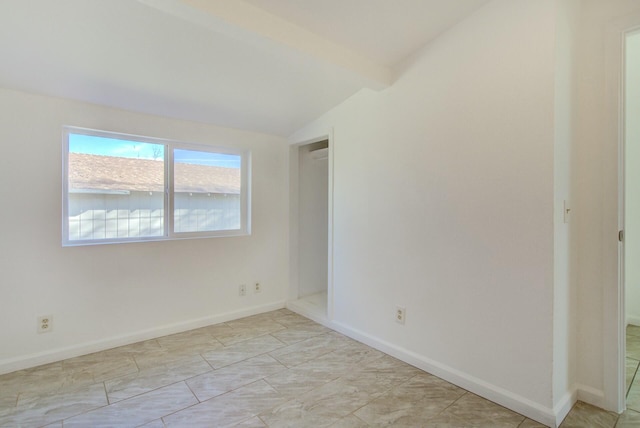 empty room featuring lofted ceiling