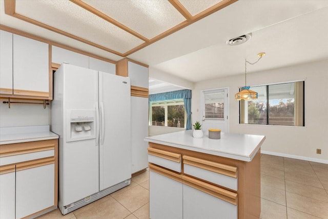 kitchen with white cabinets, pendant lighting, light tile patterned flooring, and white refrigerator with ice dispenser