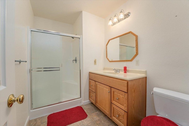 bathroom with vanity, an enclosed shower, and toilet