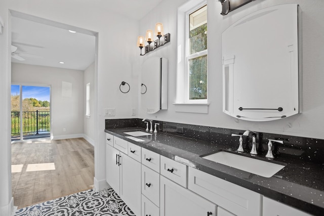 bathroom with wood-type flooring, vanity, and ceiling fan