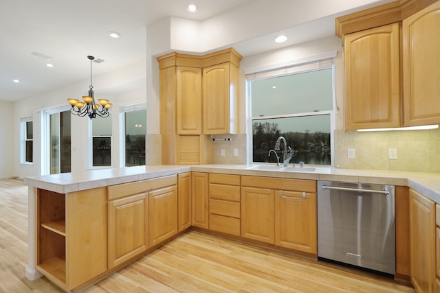 kitchen with kitchen peninsula, a chandelier, stainless steel dishwasher, and decorative backsplash