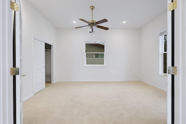 unfurnished bedroom with ceiling fan, light carpet, and a closet