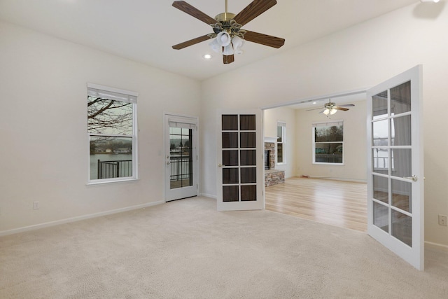 unfurnished room with ceiling fan, light carpet, and french doors