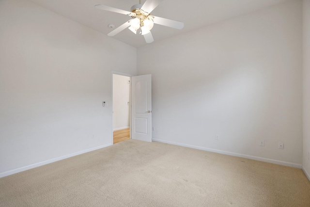 empty room with light carpet, a high ceiling, and ceiling fan