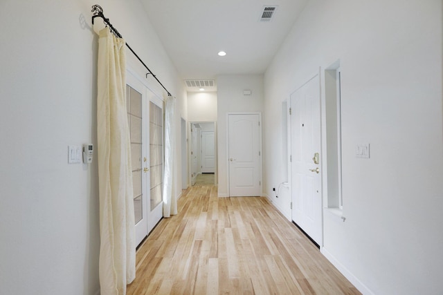 hallway with french doors and light wood-type flooring