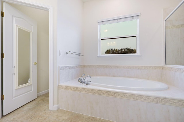 bathroom featuring tile patterned flooring and tiled tub