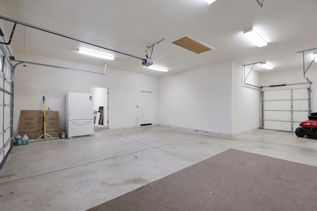 garage with white fridge and a garage door opener