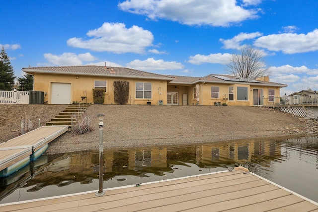 back of property with central AC and a water view