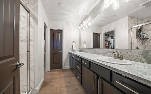 bathroom featuring vanity, wood-type flooring, and a shower with shower door