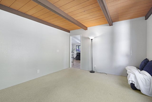 unfurnished room with beamed ceiling, carpet floors, and wood ceiling